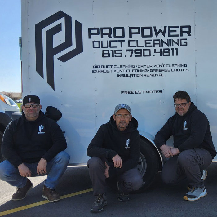 Pro Power Duct Cleaning team crouched next to a work trailer in Anitoch, IL
