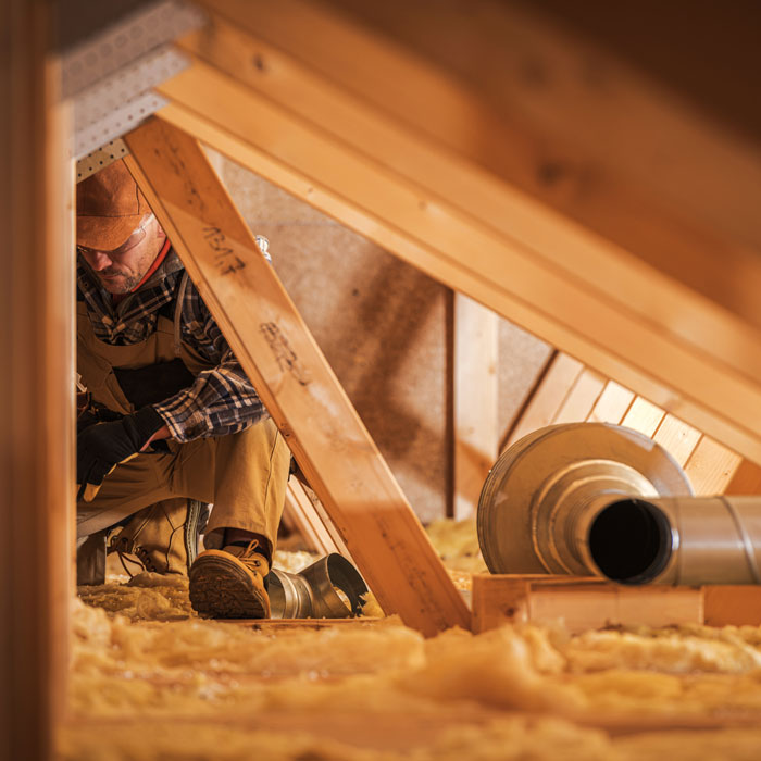 man in attic with insulation